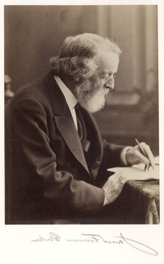 Black-and-white photograph of a white man with gray hair, 胡子, and glasses seated at a desk writing. Below the photograph is the signature “James Freeman Clarke.” 